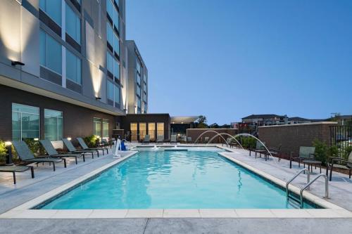 uma piscina com cadeiras e um edifício em SpringHill Suites by Marriott Dallas Richardson/University Area em Dallas
