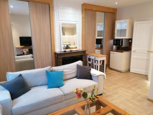 ein Wohnzimmer mit einem weißen Sofa und einer Küche in der Unterkunft APPART Standing BRANLY in Boulogne-sur-Mer
