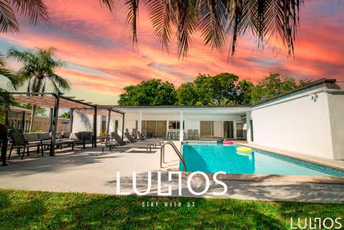 カトラー・ベイにあるStylish Retreat Heated Pool Basketball Game Room L41の夕日を望むスイミングプール付きのヴィラ
