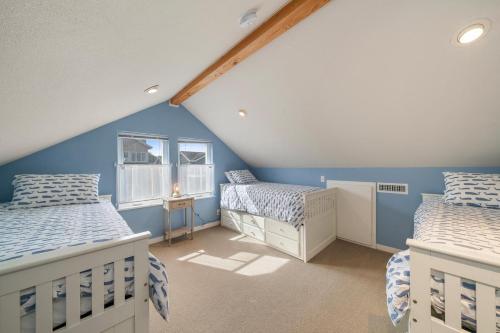a attic room with two beds and a window at The Cachalot MCA#4046 in Manzanita