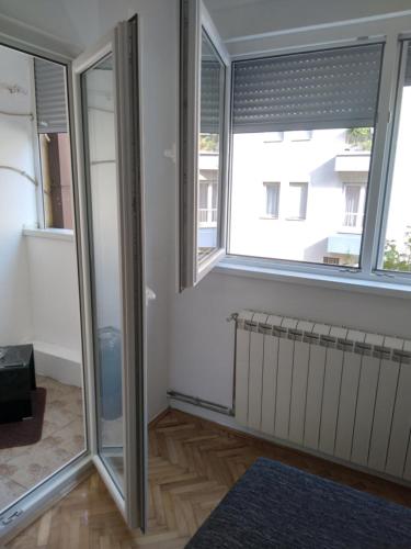 a room with two windows and a radiator at APARTMAN MARKOVIC in Loznica