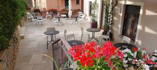 a patio with tables and chairs and red flowers at Villa Vilù in Bellosguardo