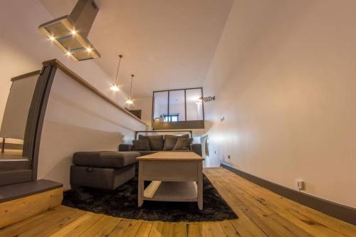 a living room with a couch and a table at Joli loft atypique - Métro Valmy in Lyon