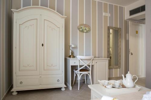 Cette chambre comprend une armoire blanche, un bureau et un miroir. dans l'établissement Villa Vilù, à Bellosguardo