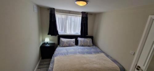 a small bedroom with a bed and a window at Cosy Garden Condo in Lucan