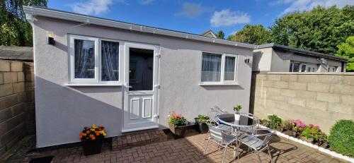 una pequeña casa con una puerta blanca y una valla en Cosy Garden Condo, en Lucan