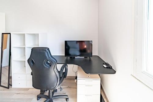 a black desk with a computer and a chair at Studio cosy - Villeurbanne Vaulx en Velin in Villeurbanne
