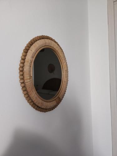 a round mirror hanging on a white wall at MARÈ Terracina Suites in Terracina