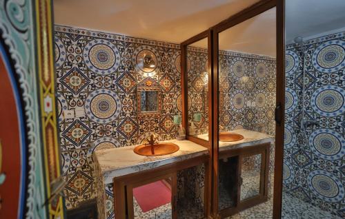 Baño con 2 lavabos y espejo en Dar Elinor, en Fez