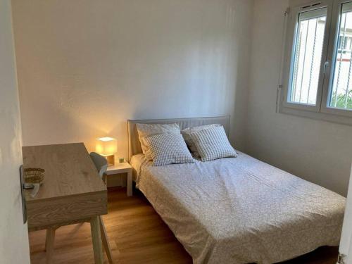 une chambre avec un lit, une table et une fenêtre dans l'établissement Le grand large 3 pièces en rez de jardin, avec terrasse et accès direct à la plage à pied, au Barcarès