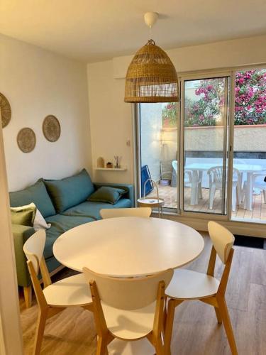 un salon avec une table et un canapé dans l'établissement Le grand large 3 pièces en rez de jardin, avec terrasse et accès direct à la plage à pied, au Barcarès