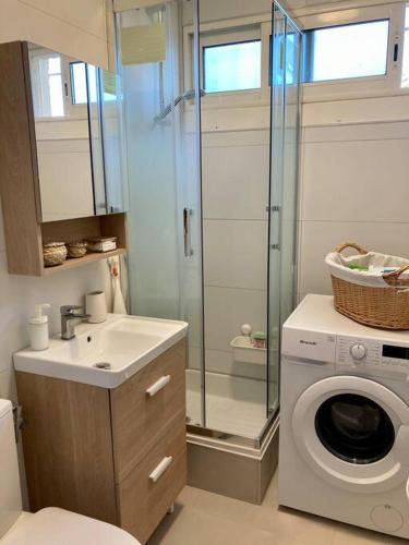 une salle de bain avec une machine à laver et un lave-linge dans l'établissement Le grand large 3 pièces en rez de jardin, avec terrasse et accès direct à la plage à pied, au Barcarès