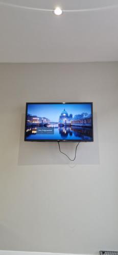 a flat screen tv hanging on a wall at Cosy Garden Condo in Lucan