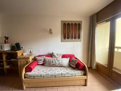 - un canapé dans le salon avec des oreillers rouges et blancs dans l'établissement Beau F2 Idéalement situé, à Orcières