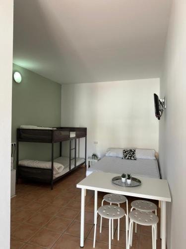 a room with a bed and a table and two stools at #13 Mini ESTUDIO FAMILIAR AYAMONTE in Ayamonte