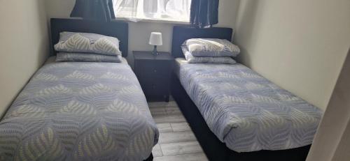 dos camas sentadas una al lado de la otra en un dormitorio en Cosy Garden Condo, en Lucan