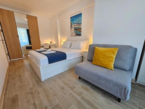 1 dormitorio con 1 cama, 1 sofá y 1 silla en Anomis Infinity Pool & SPA Resort Sea-View, en Mamaia Nord – Năvodari