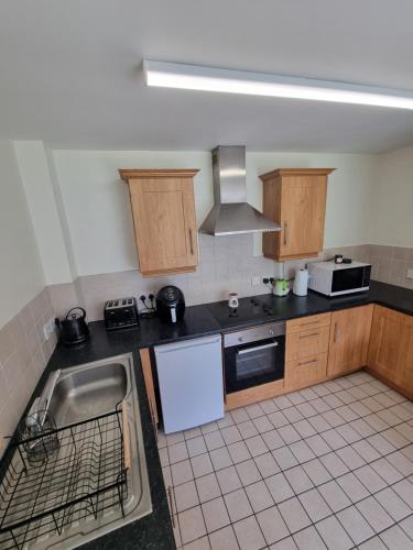 a kitchen with a sink and a stove at Donard View Apartment in Newcastle