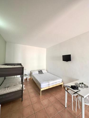 a room with two beds and a tv on the wall at #13 Mini ESTUDIO FAMILIAR AYAMONTE in Ayamonte