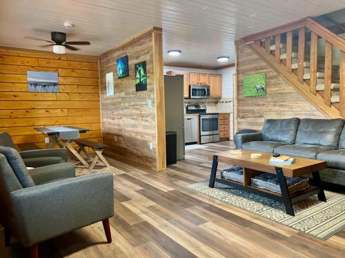 uma sala de estar com sofás e uma mesa e uma cozinha em Aurora Ridge Cabin em Fairbanks