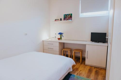a bedroom with a bed and a desk with a computer at Camelia's cozy place in Baia Mare
