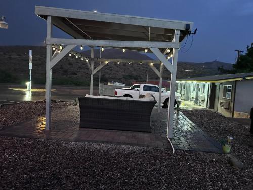a bench under a pavilion with lights in a parking lot at Belle Aire Motel in Globe