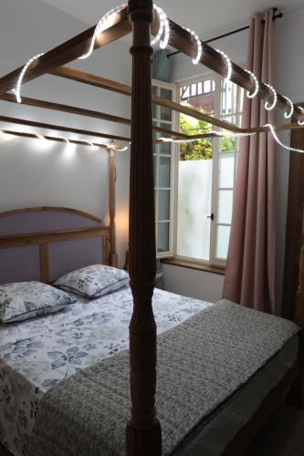 a bedroom with a four poster bed and a window at Atelier des Glycines, Troyes Bouchon de Champagne, Sublime site patrimonial in Troyes