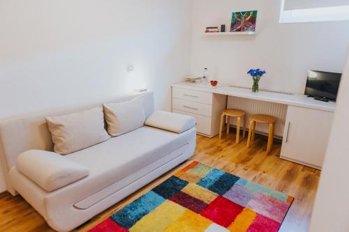 a living room with a white couch and a kitchen at Camelia's cozy place in Baia Mare