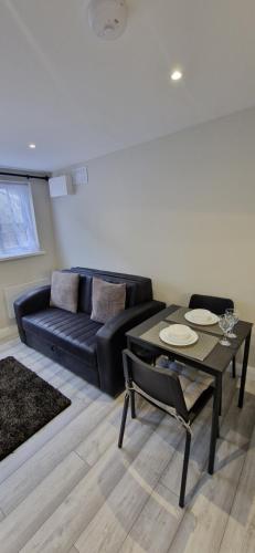 a living room with a black couch and a table at Cosy Garden Condo in Lucan