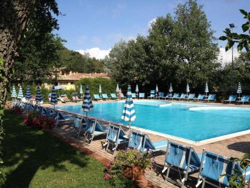 un grupo de sillas y sombrillas junto a una piscina en 14 Toscana da Vilma, vacanza, piscina - CASA PRIVATA en Castel del Piano