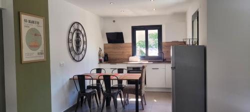 une cuisine avec une table, des chaises et un réfrigérateur dans l'établissement Casarella Alzia, à Santa-Reparata-di-Balagna