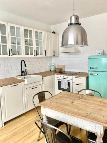 uma cozinha com uma mesa de madeira e um frigorífico azul em Family Ski apartment em Spindleruv Mlyn