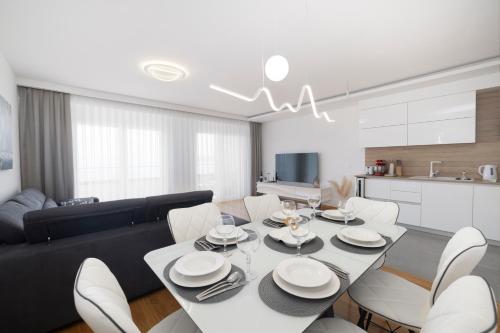 een eetkamer en een woonkamer met een tafel en stoelen bij LuSi Apartman Makarska in Makarska