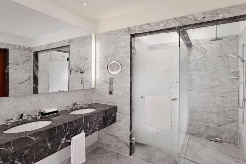 a bathroom with two sinks and a shower at The Ritz-Carlton, Vienna in Vienna