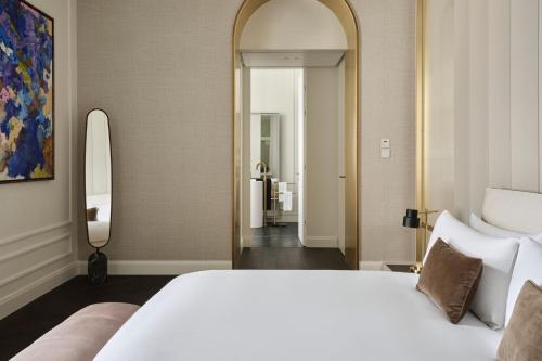 a bedroom with a large white bed and a mirror at The Ritz-Carlton, Vienna in Vienna