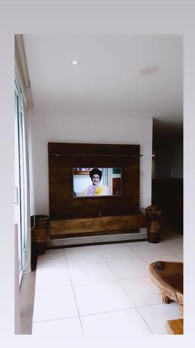 a living room with a flat screen tv on a wall at Pippo Suites Guarujá in Guarujá
