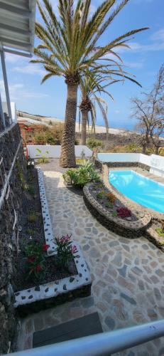 un complejo con piscina y palmeras en Casa Moja - La Palma en Tazacorte