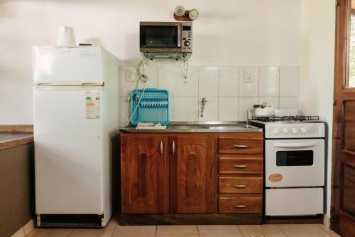 a kitchen with a white refrigerator and a stove at Complejo Paranay in Puerto Paranay