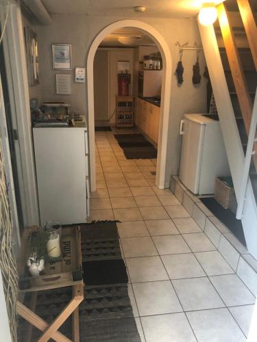 a kitchen with a tile floor and an archway at Guesthouse Trabjerg in Vejle