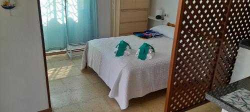 ein Schlafzimmer mit einem Bett mit grünen Handtüchern darauf in der Unterkunft La Cruz del Sur in Sanxenxo