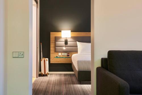 a hotel room with a bed and a couch at Moxy Southampton in Southampton