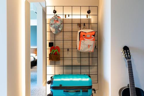 a room with luggage and bags hanging on a wall at Moxy Southampton in Southampton