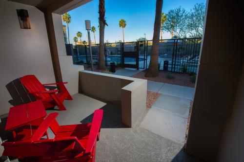 two red chairs on a balcony with palm trees at MOXY Phoenix Tempe/ASU Area in Tempe