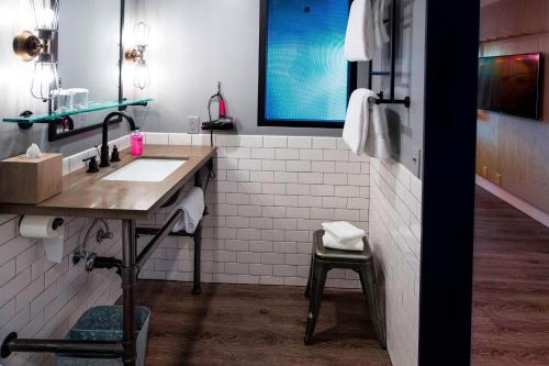 ein Bad mit einem Waschbecken und einem Spiegel in der Unterkunft MOXY Phoenix Tempe/ASU Area in Tempe