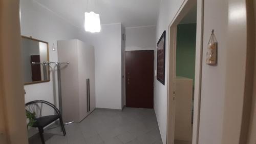 a hallway with a door and a chair in a room at MetroNear in Collegno