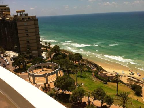 een uitzicht op het strand en de oceaan vanuit een gebouw bij Nitza Seaview Apartments in Netanya