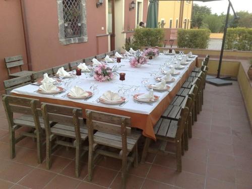 a long table with chairs and plates and flowers on it at La Terra Del Mezzo in Riposto