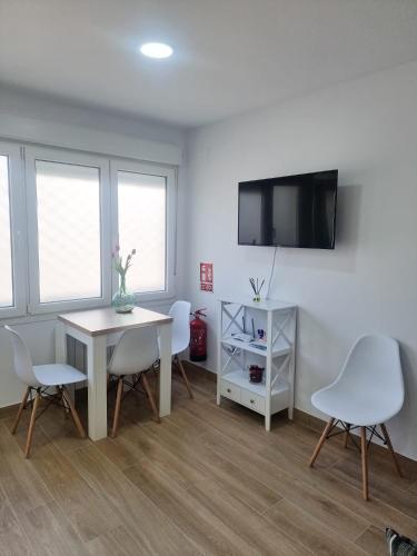 sala de estar con mesa, sillas y TV en Apartamento Regina, en Santiago de Compostela