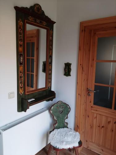a mirror and a chair in front of a door at Haus Waldblick in Liebenwalde