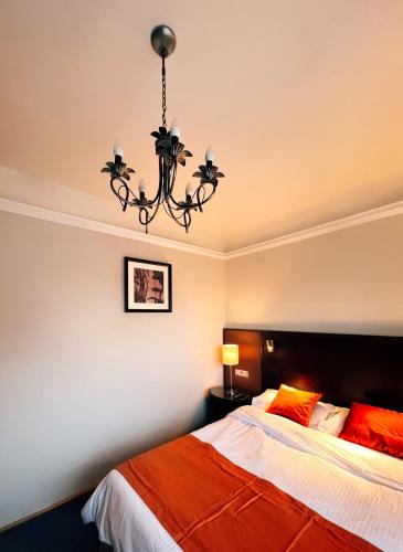 a bedroom with a bed and a chandelier at Excelsior INN in Turda